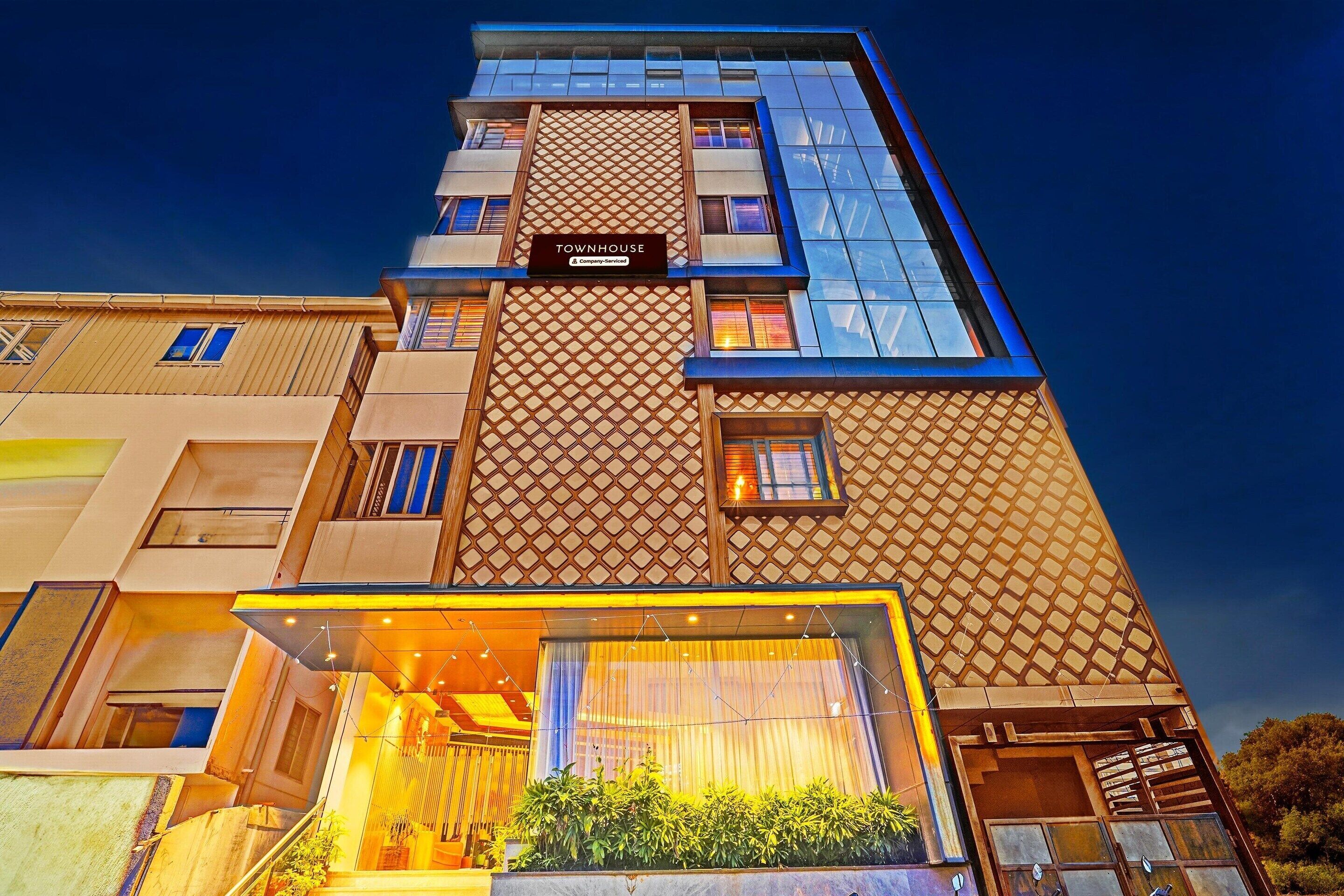 A multi-story hotel with a modern design, featuring a prominent 'Townhouse' sign and a glass facade.