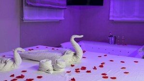 Una habitación con una cama, un televisor montado en la pared y una ventana con persianas.