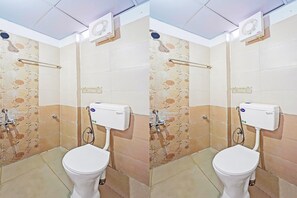 Une salle de bain équipée de toilettes, d’une douche et d’un sèche-mains.