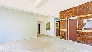A hallway with a marble wall, a reception desk, and a door with a 'Lift' sign. - Deluxe spl Palace (Chennai)