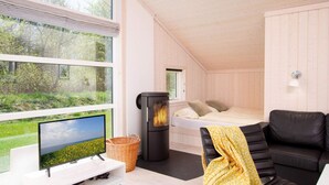 A cozy room with a bed, a television, and a fireplace. - 4 Star Holiday Home in Grossenbrode (Grossenbrode)