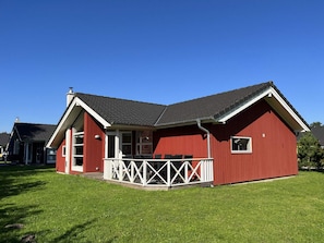 Ein rotes Gebäude mit Veranda und kleiner Terrasse.