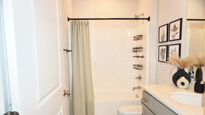 A bathroom with a bathtub, toilet, and vanity with a sink. - Modern Townhome • 17 mins from Augusta Masters (North Augusta)
