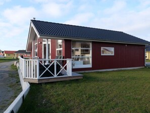 A red building with a white porch and a grey roof. - 4 Star Holiday Home in Grossenbrode (Grossenbrode)