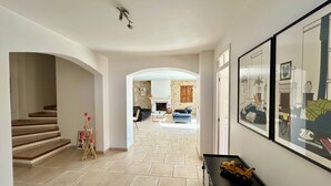 Ein geräumiger Flur mit Treppe, Kamin und einem Essbereich im Hintergrund.