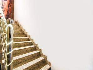 Un escalier avec des marches en granit et des rampes en acier inoxydable.