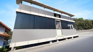 A modern building with a flat roof, large windows, and a sign that reads 'Collection.' - Super Deluxe Room Super Collection O (Gobindpur)