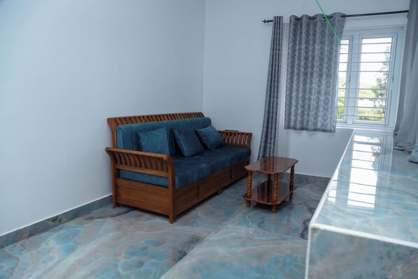 A room with a wooden sofa, a small wooden table, and a glass-top table.