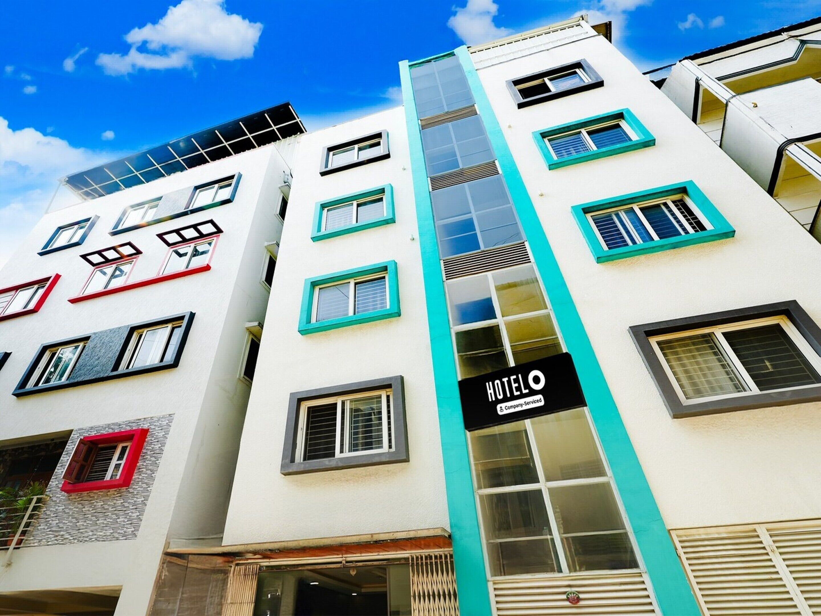 A multi-story hotel building with a prominent 'HOTELO' sign, multiple windows, and a central vertical feature.