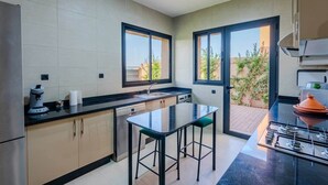 A modern kitchen with a central island, a built-in oven, and a view to a garden. - Flextay - VILLA Lounge - 4Ch - Pool - Billiards (Marrakesh)