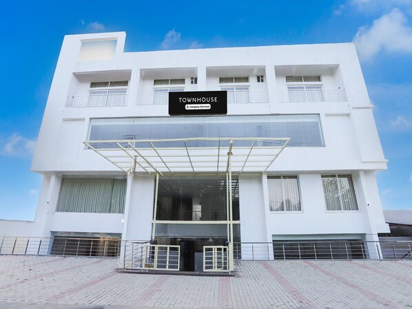 A modern white building with a sign reading 'TOWNHOUSE Company-Serviced.'