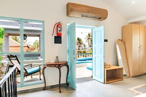 Ein Zimmer mit Blick auf einen Swimmingpool, einem Feuerlöscher, einem Holzschrank und einem Tisch mit Stühlen.