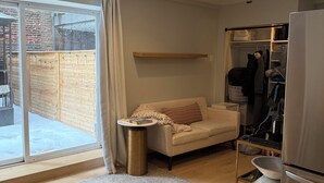 Una cocina moderna con refrigerador, mesa de comedor y sofá.