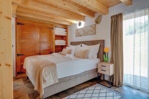 Un dormitorio con cama, armario de madera, mesita de noche y ventana con cortinas.