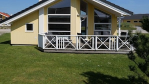 A yellow building with a white balcony, large windows, and a chimney. - 4 Star Holiday Home in Grossenbrode (Grossenbrode)