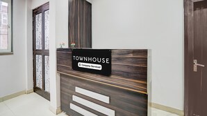 A reception desk with a sign reading 'TOWNHOUSE Company-Serviced' and a wooden panel design. - Deluxe With Twin Bed Hotel Sky Inn (Lucknow)