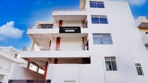 A multi-story building with a sign reading 'TOWNHOUSE & Company Services.' - Deluxe With Twin Bed Hotel Sky Inn (Lucknow)