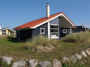 A modern house with a red roof, large windows, and a chimney. - 4 Star Holiday Home in Grossenbrode (Grossenbrode)