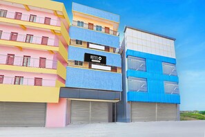 A multi-story hotel with balconies, a sign reading 'HOTEL O & Company Services,' and a blue and yellow facade. - Super Hotel O Yeshwanthpur (Bengaluru)