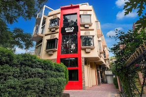 A hotel building with a red vertical stripe, balconies, and a clear sky. - Classic With Balconyroyal Inn (Durgapur)