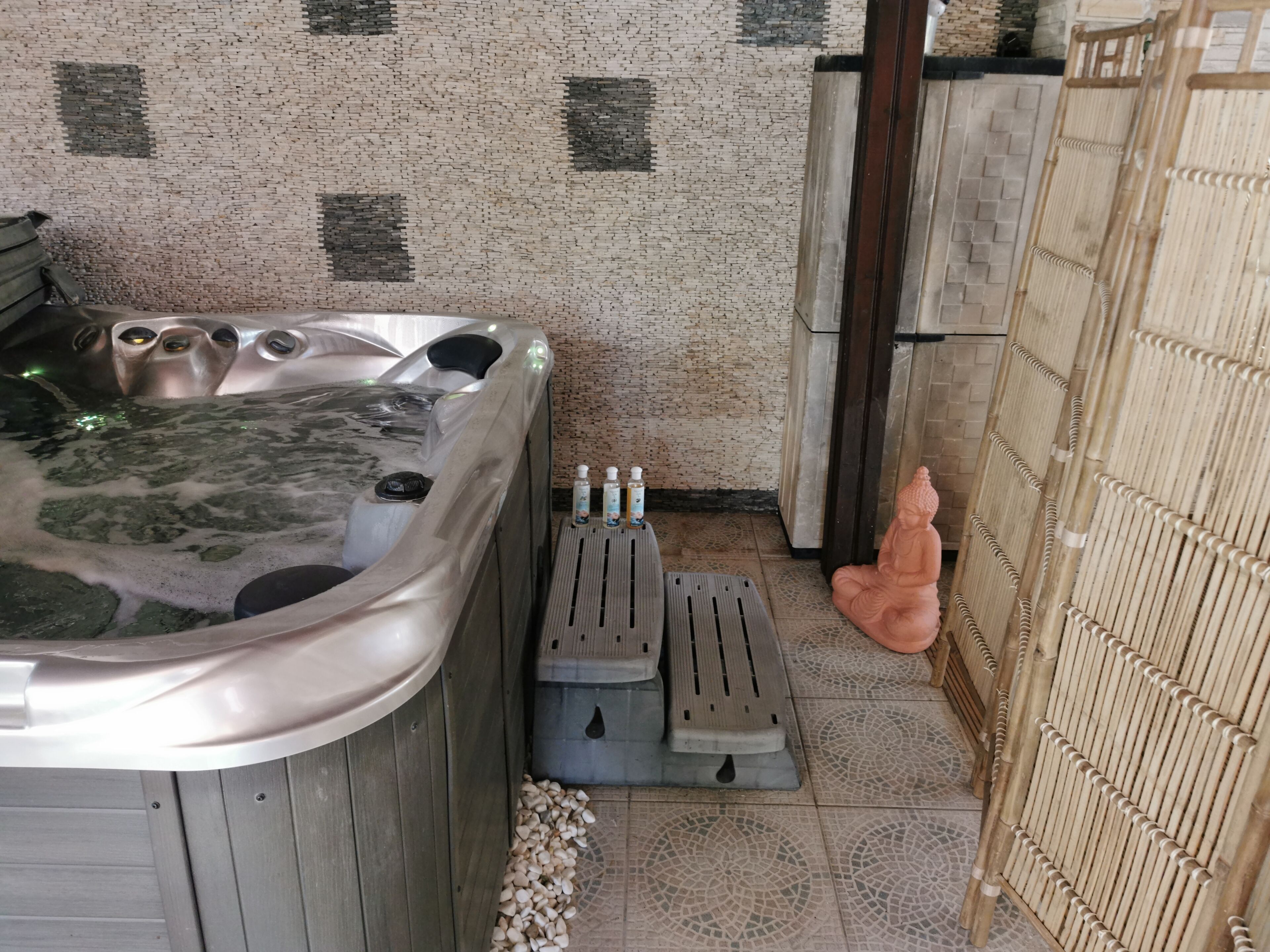Un área de spa con hidromasaje, un baño de pies y una estatua.
