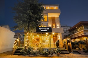 Een modern herenhuis met een bord waarop staat 'TOUNHOUSE Company-Serviced'.