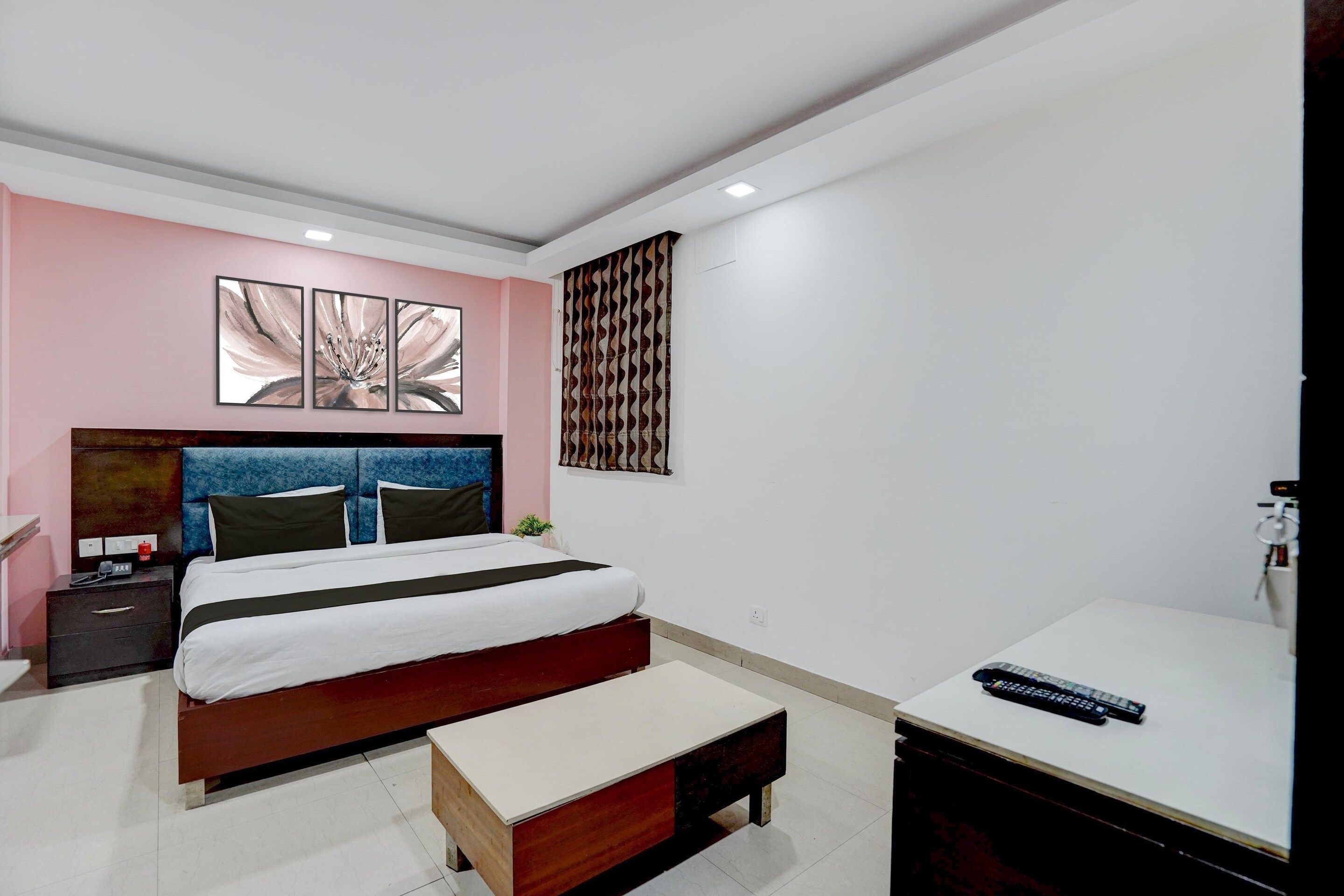 Une chambre à coucher comprenant un lit, une table de chevet, un banc et un bureau avec une chaise.