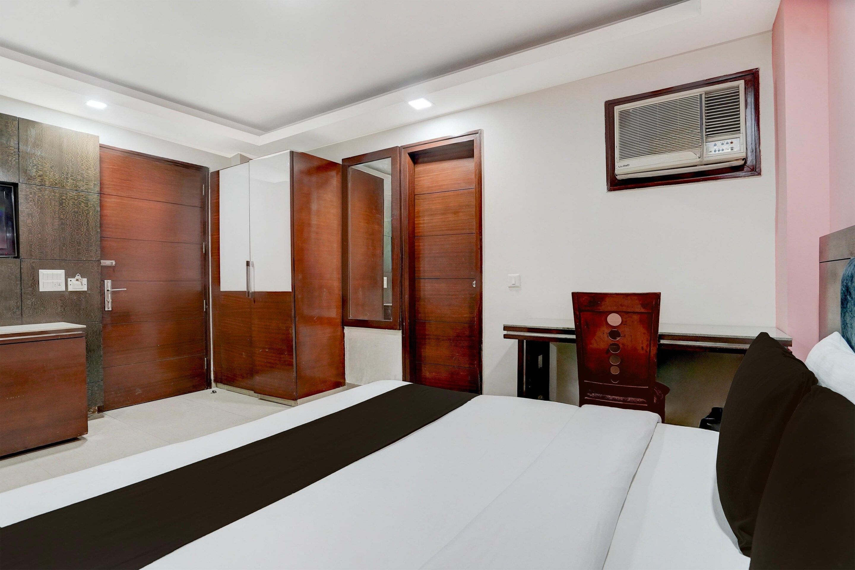 A bedroom with a bed, wardrobe, and a desk with a chair.