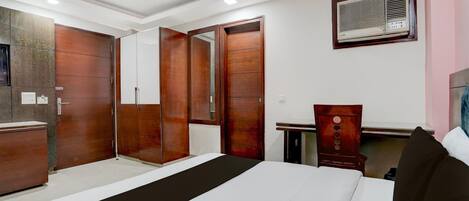 A bedroom with a bed, wardrobe, and a desk with a chair.