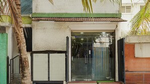 A building entrance with a glass door, a green awning, and a metal gate. - Deluxe Collection O Kalyan Nagar Bangalore (Bengaluru)