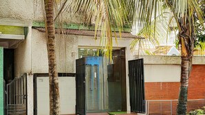 A building entrance with a glass door, palm trees, and a staircase leading up. - Deluxe Collection O Kalyan Nagar Bangalore (Bengaluru)