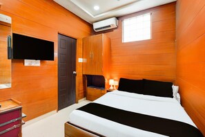 Quarto com cama, televisão na parede, guarda-roupa e ar condicionado.