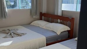 A hotel room with two beds, a large window with a view, and an air conditioning unit. - Hotel beira rio OPK (Oiapoque)