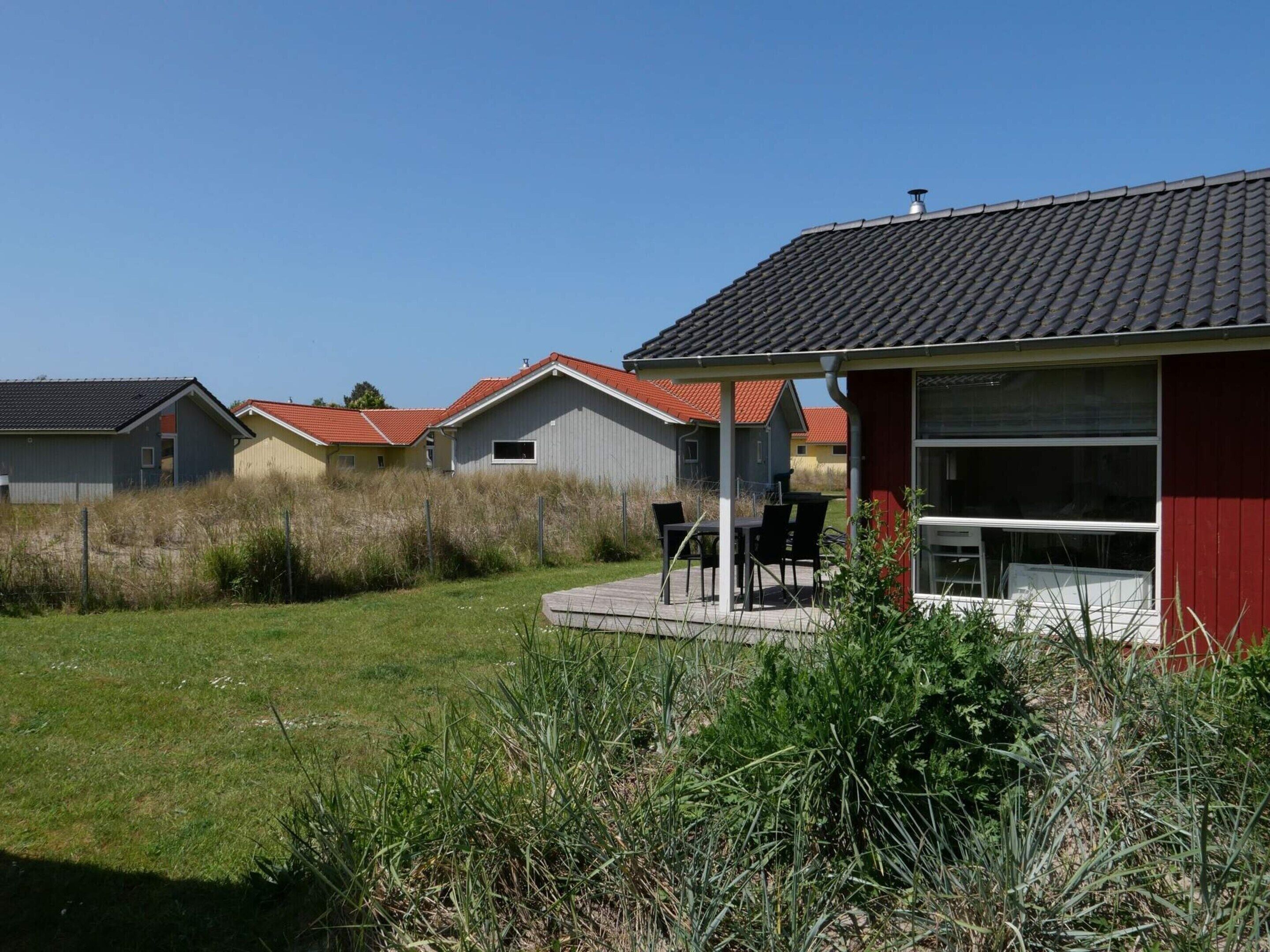 A row of houses with a grassy yard and a covered outdoor seating area.