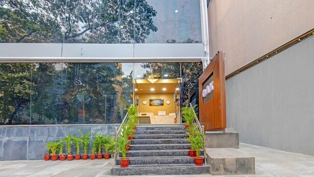 Un escalier menant à un espace d’accueil, avec des plantes en pot à sa base.