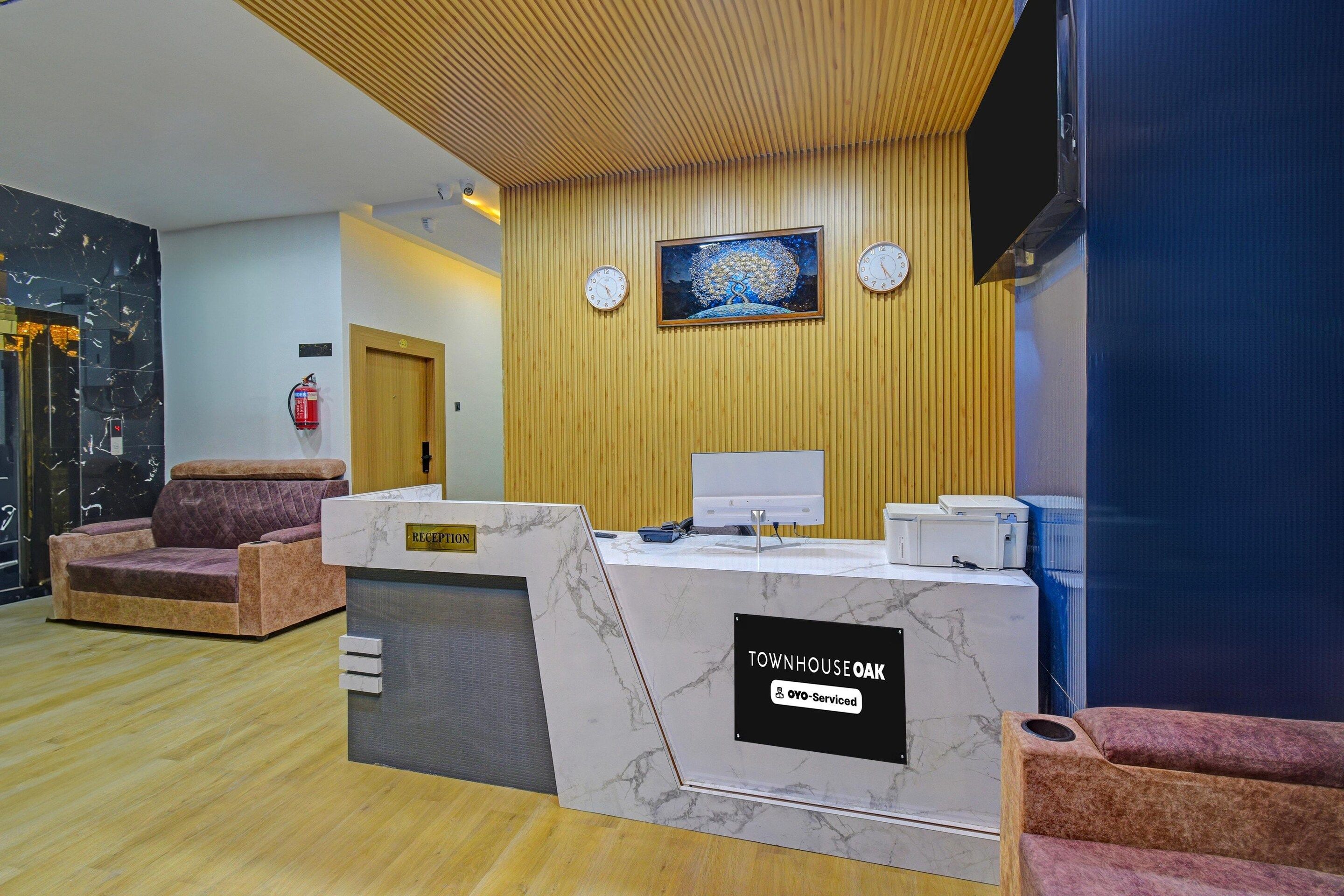A reception desk with a 'Townhouse Oak' sign, a clock, and a painting on the wall.