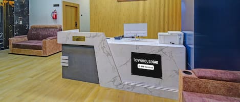A reception desk with a 'Townhouse Oak' sign, a clock, and a painting on the wall.