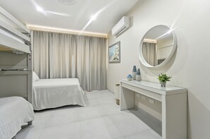 Ein Hotelzimmer mit Bett, Nachttisch, Spiegel und Klimaanlage.