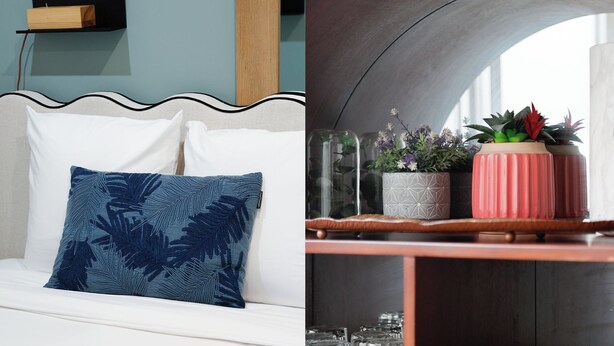 A room with a white sofa, a blue patterned pillow, a wooden shelf with glass vases, and a wooden cabinet with glassware. - Cosy & lumineux – 3 pers – Paris centre (Paris)