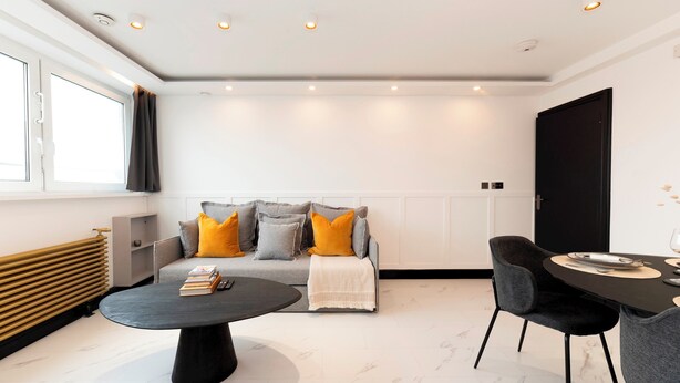 A modern living room with a sofa, coffee table, and dining area. - Luxury One Bedroom Apartment, Holland Park and Next to Notting Hill - Pass the Keys (London)