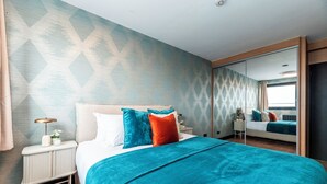 A bedroom with a bed, a bedside table, a mirror, and a patterned wall. - Luxury One Bedroom Apartment, Holland Park and Next to Notting Hill - Pass the Keys (London)