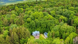 Ein Haus, umgeben von dichtem Wald, mit freiem Blick auf die umliegenden Hügel.