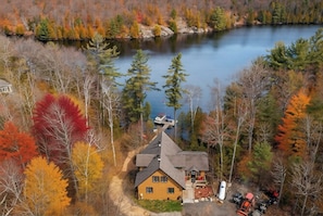 A cabin with a dock, surrounded by autumn-colored trees and a lake. - Beautiful Comfortable Modern Home on a Quiet Lake surrounded by wilderness. (Baysville)