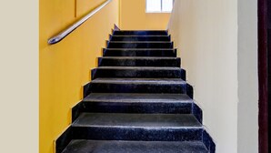 A staircase with black steps leading upwards, flanked by yellow walls, and a window at the top. - Classic With Balcony Ganeshguri Nayanpur (Guwahati)