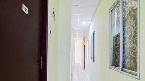 A hallway with a door labeled '107', a tiled floor, and patterned window treatments. - Classic With Balcony Ganeshguri Nayanpur (Guwahati)