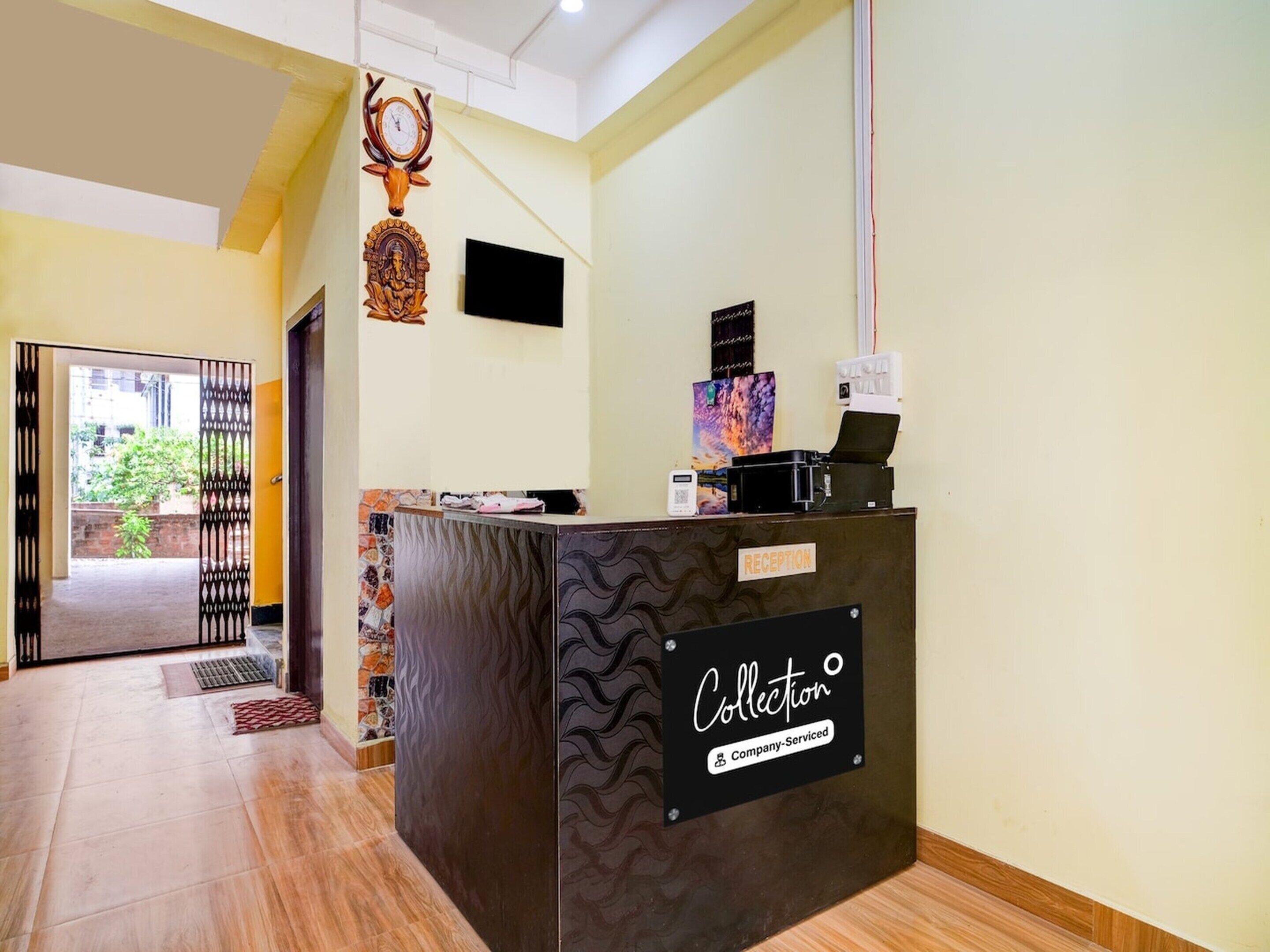 A reception desk with a 'Collection' sign, a clock, and a decorative deer head.