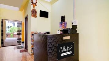 A reception desk with a 'Collection' sign, a clock, and a decorative deer head.