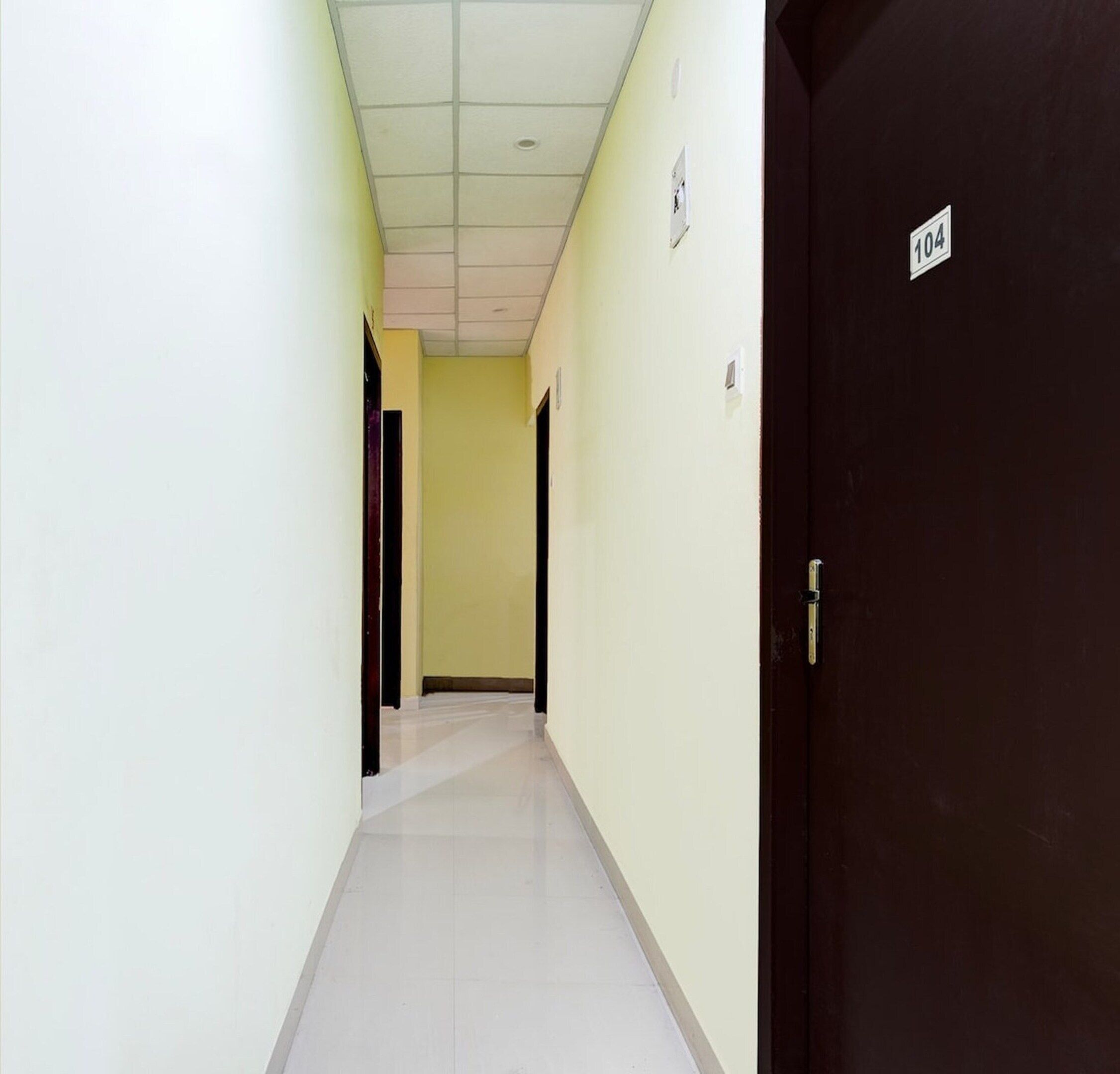 A hallway with a door labeled '104' and a light-colored tiled floor.