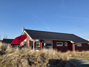 A red building with a dark roof, a red umbrella, and a number '125' sign. - 4 Star Holiday Home in Grossenbrode (Grossenbrode)