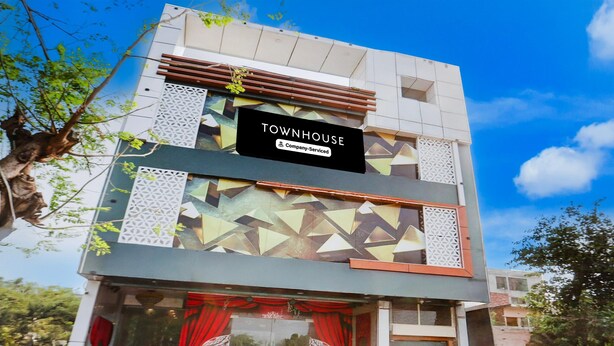 Un edificio moderno con un letrero que dice 'TOWNHOUSE' y el logotipo de la empresa.